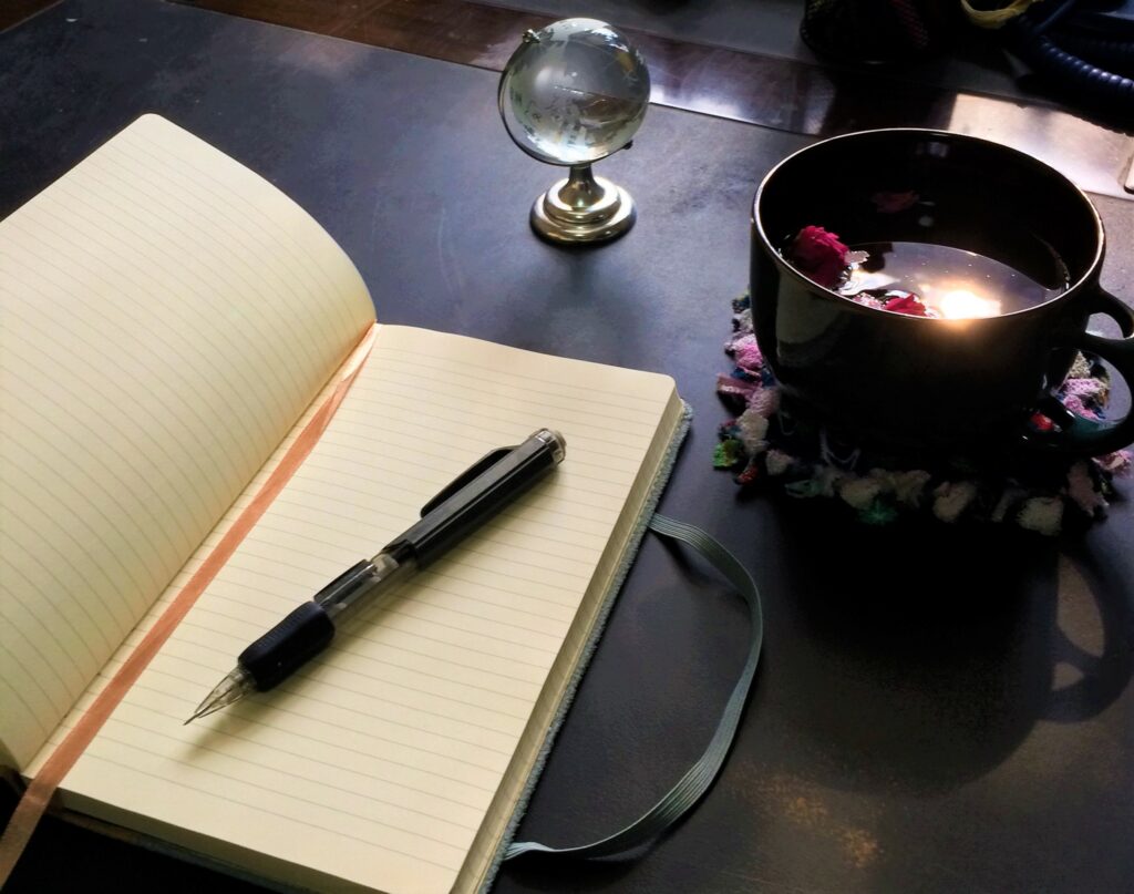 Journal and rose water with the morning sun